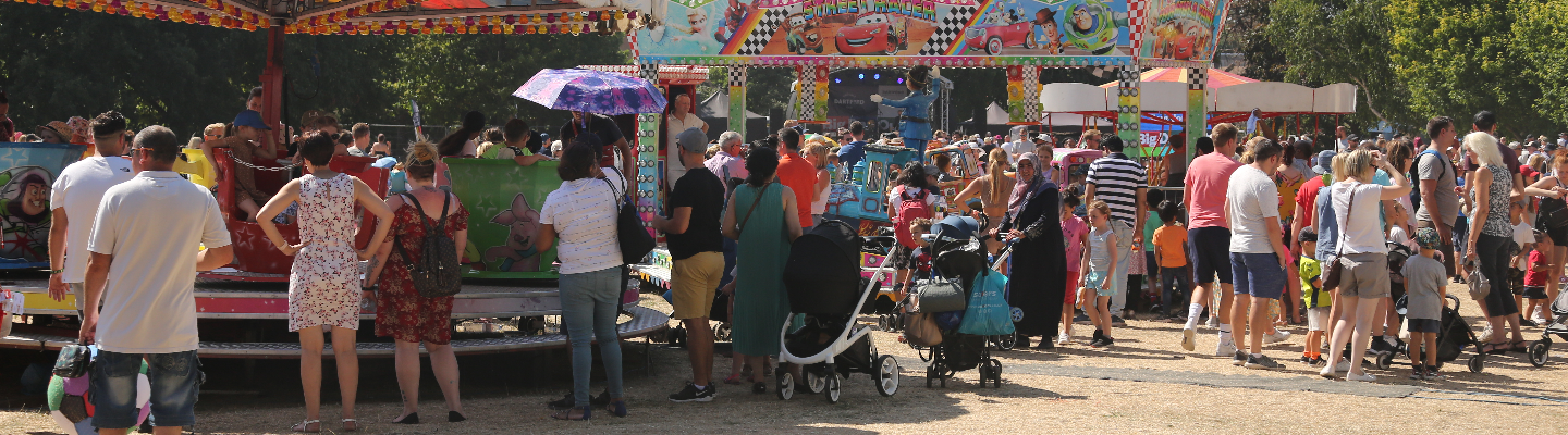 Crowd enjoying fairground rides at Dartford's Big Day Out